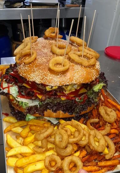 Big Dora: 8.667 g schwerer Riesenburger mit Pommes und Zwiebelringen, Blick von oben auf das volle Tablett